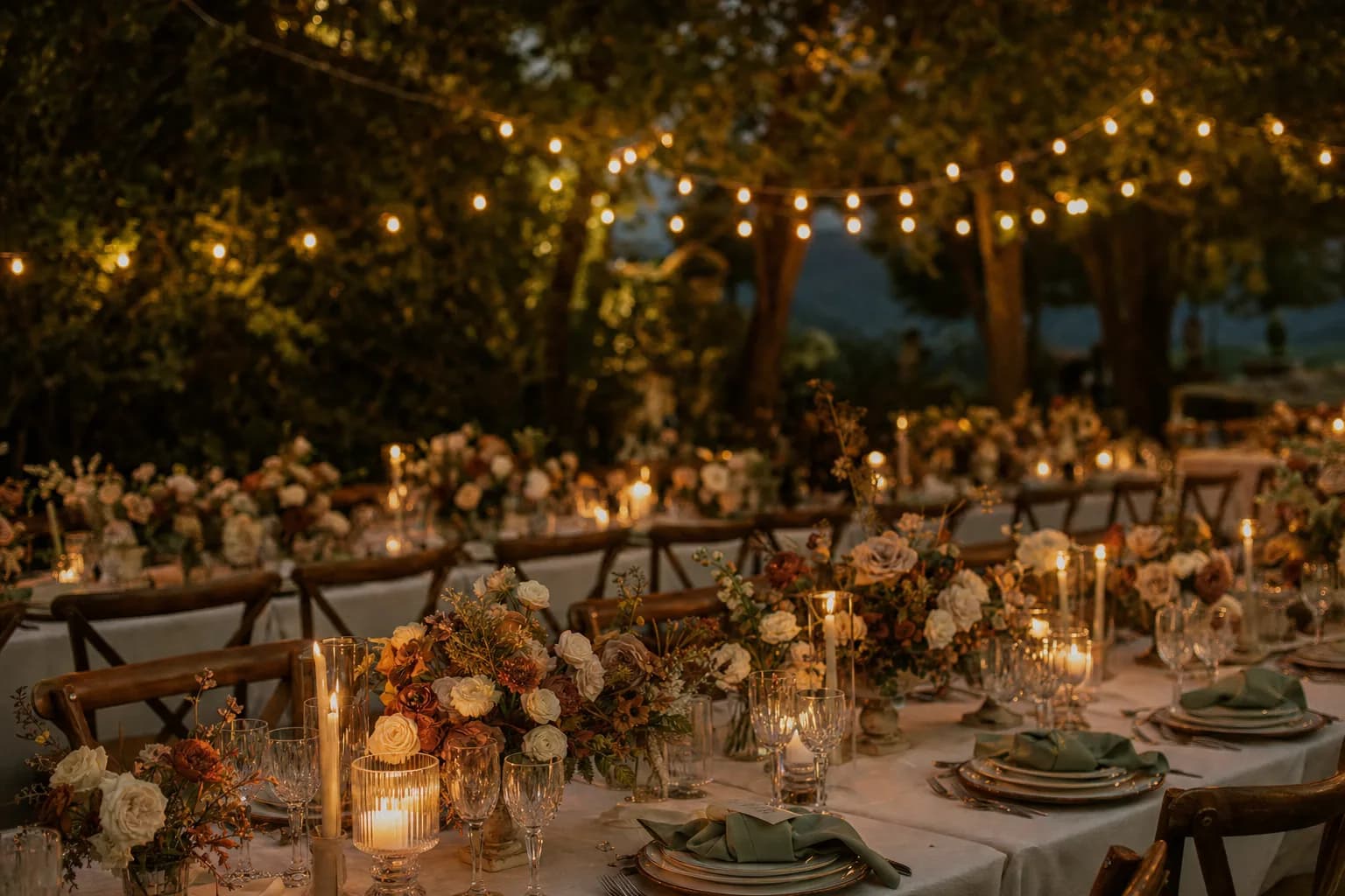 A candlelit outdoor reception glowing under warm string lights